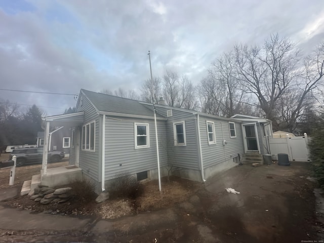 view of home's exterior featuring entry steps and fence