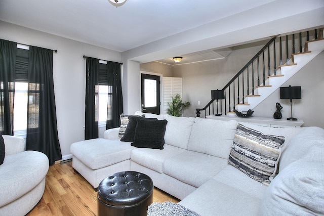 living room featuring light wood finished floors and stairs