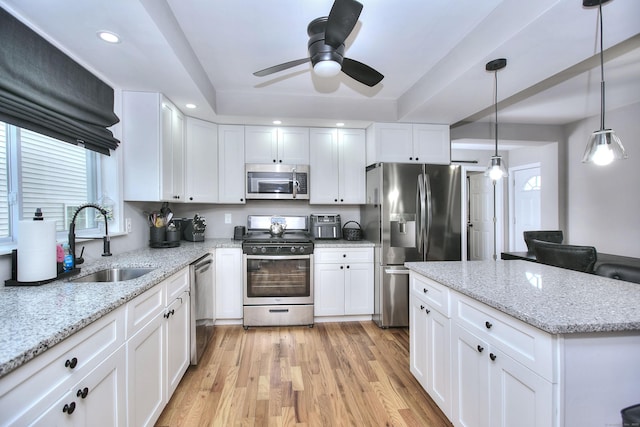 kitchen featuring light wood-style flooring, appliances with stainless steel finishes, white cabinetry, a sink, and recessed lighting