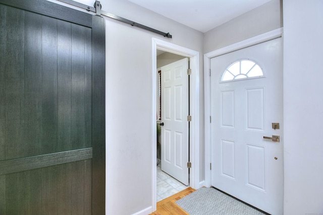 foyer with a barn door and light wood-style flooring