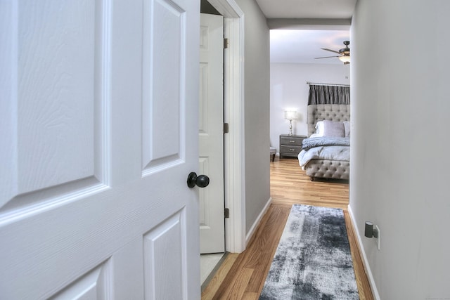 corridor with wood finished floors and baseboards