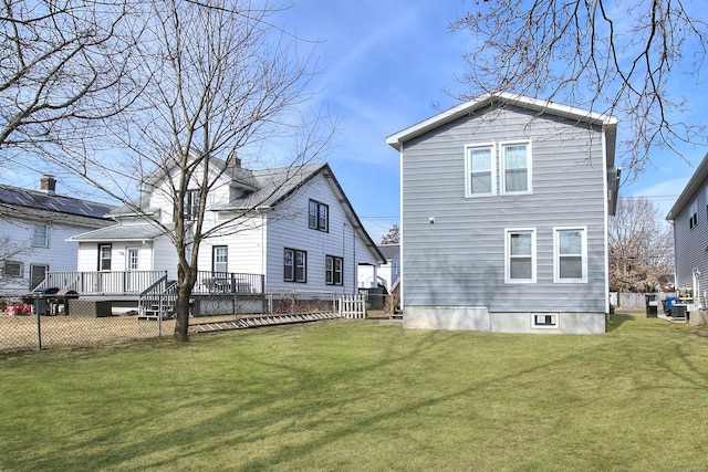 back of property with a yard and fence