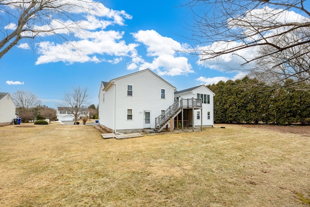 back of property featuring stairs, a lawn, and a wooden deck