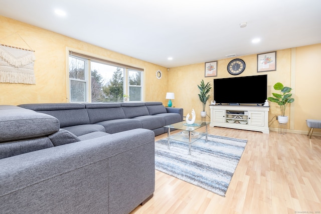 living room with recessed lighting, visible vents, baseboards, and wood finished floors