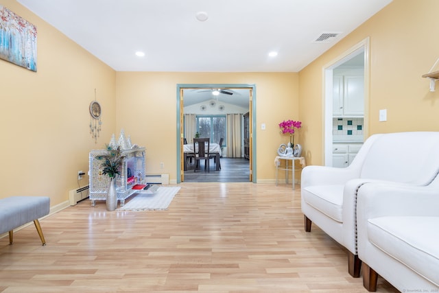 sitting room featuring light wood-style floors, visible vents, and baseboard heating