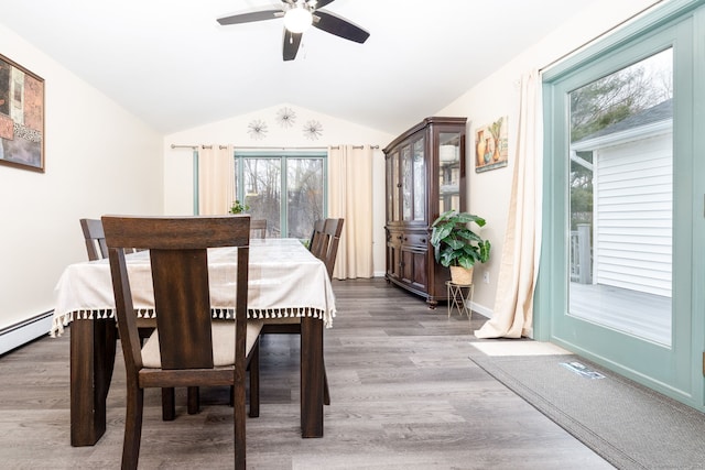 dining space featuring baseboards, visible vents, ceiling fan, wood finished floors, and vaulted ceiling