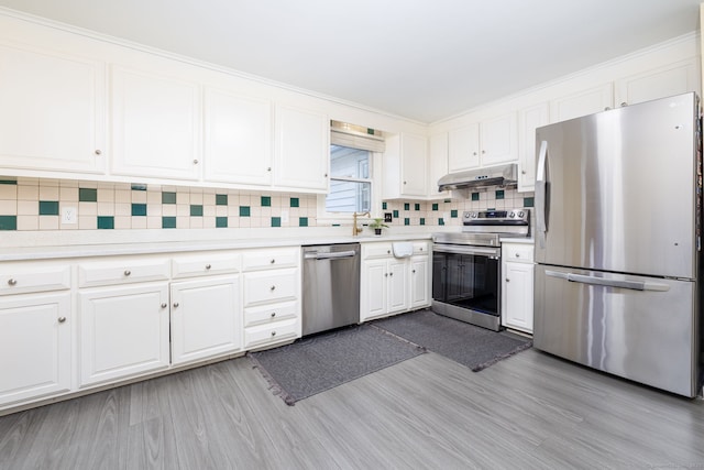 kitchen featuring under cabinet range hood, white cabinetry, appliances with stainless steel finishes, light wood-type flooring, and tasteful backsplash