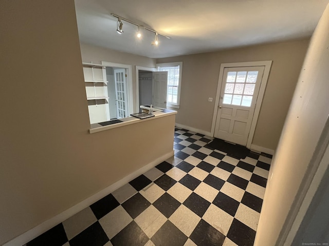 foyer with baseboards and tile patterned floors