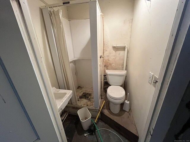 full bathroom featuring toilet and a stall shower