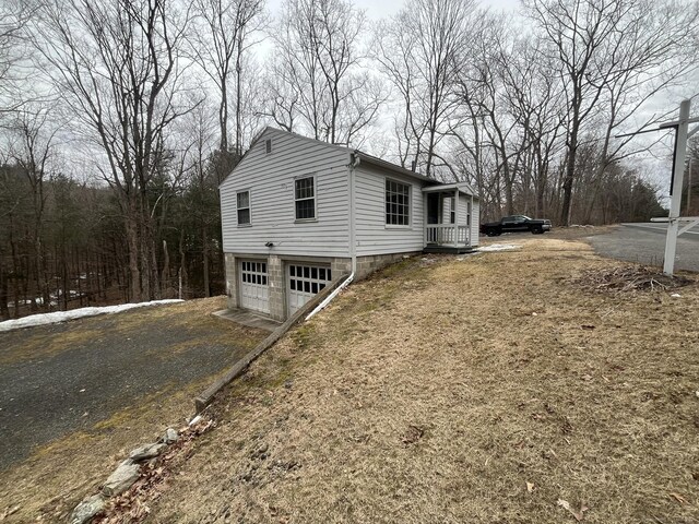 view of side of home featuring driveway and an attached garage