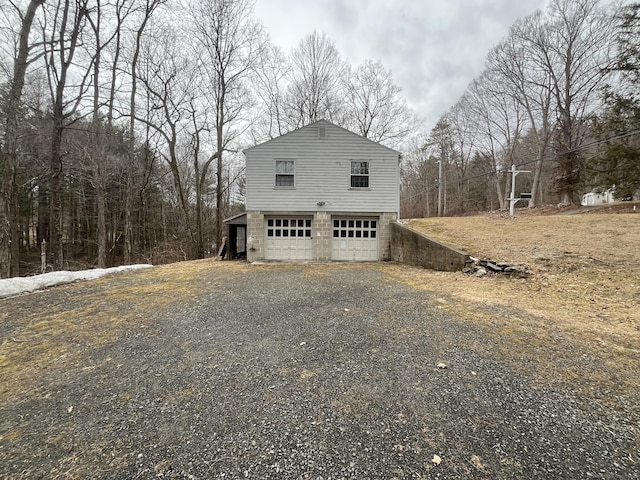 view of side of home with gravel driveway