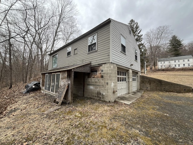 exterior space featuring an attached garage and dirt driveway