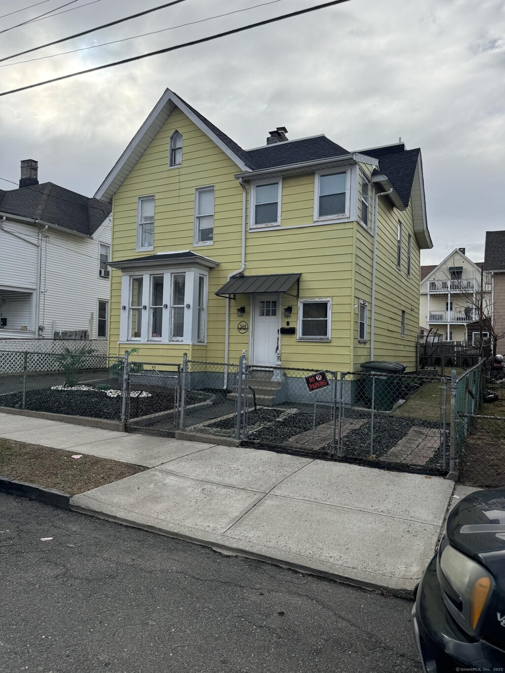 traditional home featuring a fenced front yard, entry steps, and a gate