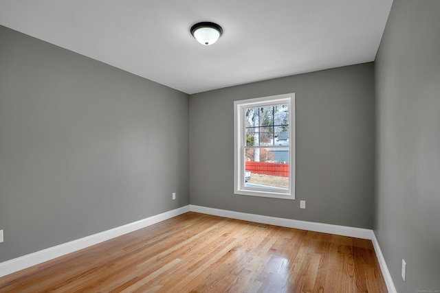 spare room with light wood-style flooring, visible vents, and baseboards