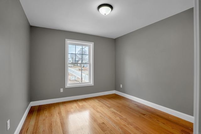 empty room with light wood-type flooring and baseboards