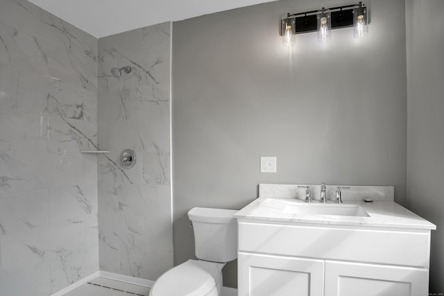 bathroom featuring toilet, a marble finish shower, and vanity