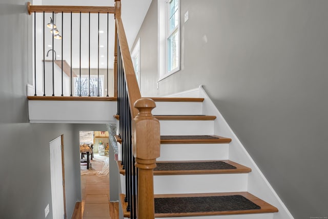 staircase with a towering ceiling and a wealth of natural light