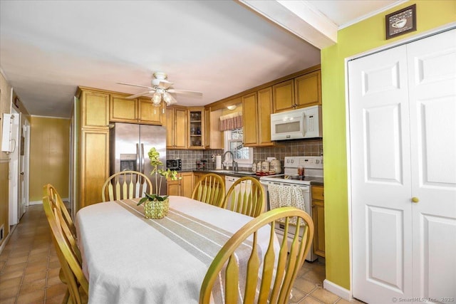 dining room featuring light tile patterned floors, crown molding, and ceiling fan