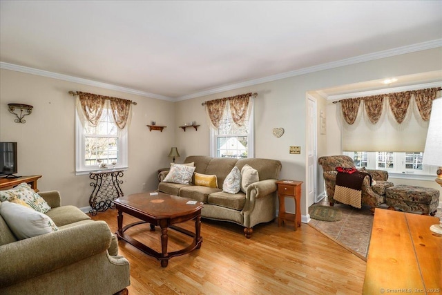 living area featuring plenty of natural light, light wood-type flooring, and ornamental molding