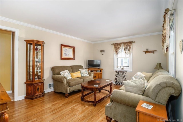 living area featuring visible vents, light wood-style floors, and ornamental molding