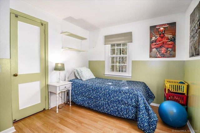 bedroom with baseboards and wood finished floors