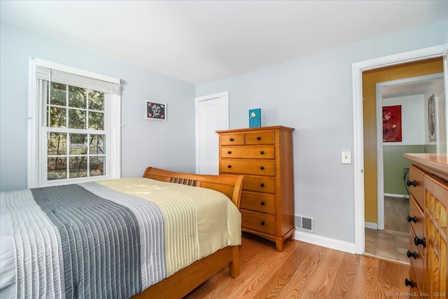 bedroom featuring light wood-style flooring, baseboards, and visible vents