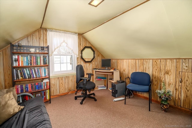 office area featuring lofted ceiling, wooden walls, and carpet