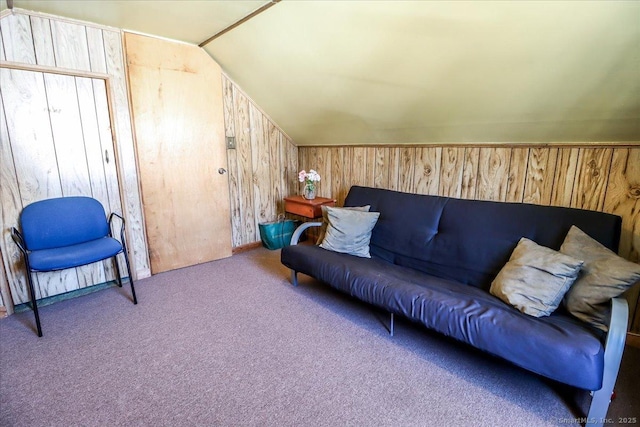 carpeted living room with lofted ceiling and wood walls