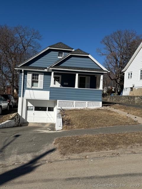 view of front facade with driveway, covered porch, and an attached garage