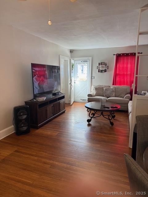 living area with baseboards and wood finished floors