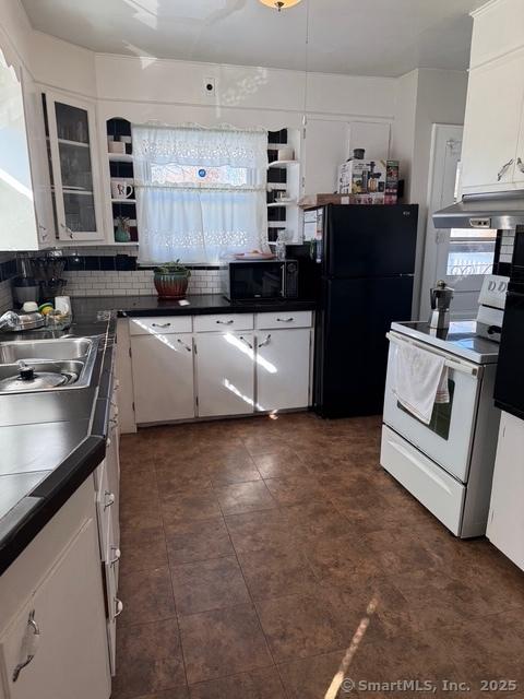 kitchen featuring black appliances, white cabinets, dark countertops, and under cabinet range hood