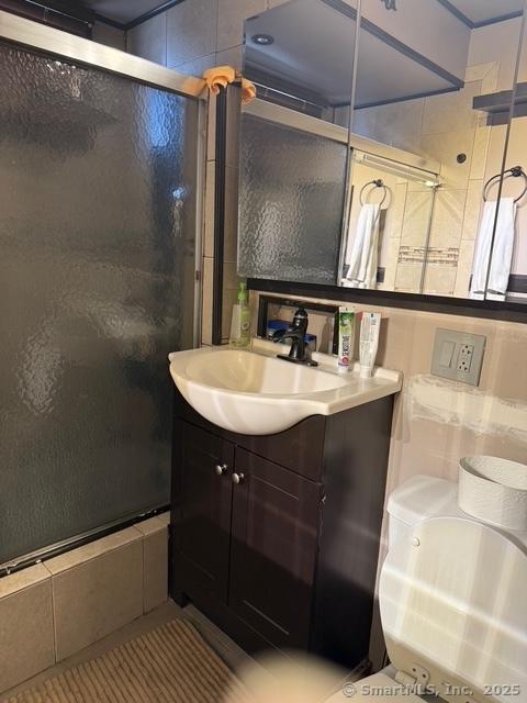 full bath with a shower stall and vanity