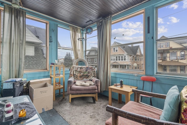 sunroom / solarium featuring wooden ceiling and a residential view