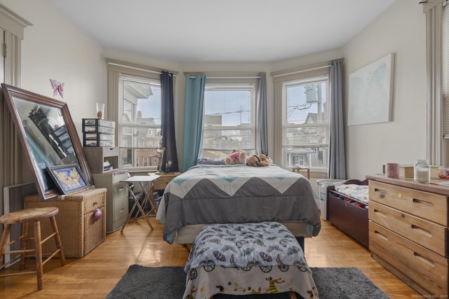 bedroom with light wood-style floors and multiple windows