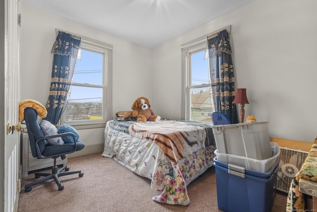 carpeted bedroom featuring multiple windows and baseboards