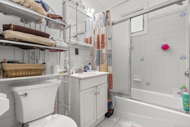 full bath featuring tasteful backsplash, shower / bath combination with glass door, tile patterned flooring, vanity, and tile walls