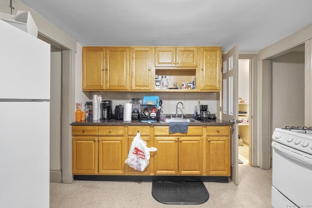 kitchen featuring white appliances, tasteful backsplash, and a sink