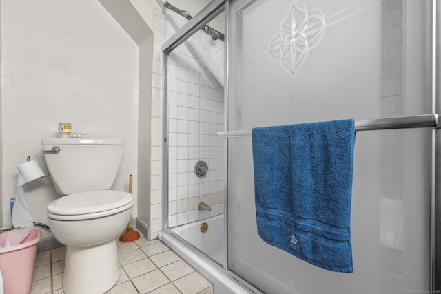 full bath with toilet, tile patterned flooring, and bath / shower combo with glass door