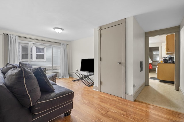 living area featuring light wood-style floors and baseboards