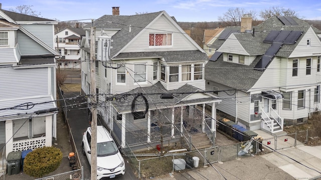 view of front of property with a shingled roof and fence