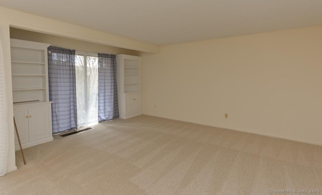 unfurnished room featuring baseboards, visible vents, and light colored carpet