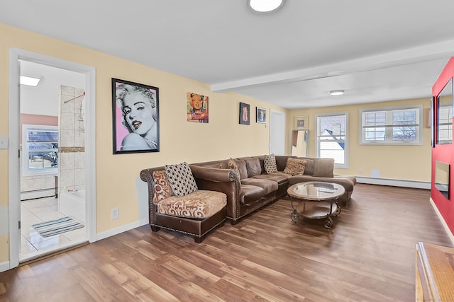 living area with beam ceiling, wood finished floors, baseboards, and a baseboard radiator