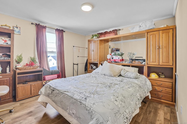 bedroom featuring crown molding and wood finished floors