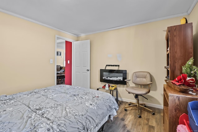 bedroom featuring crown molding, baseboards, and wood finished floors