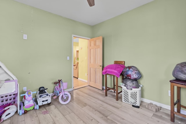 playroom with ceiling fan, baseboards, and wood finished floors