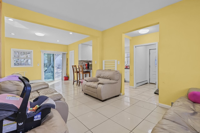 living room featuring light tile patterned floors, recessed lighting, baseboards, and a baseboard radiator