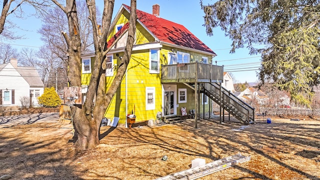 rear view of house with stairway, a chimney, and entry steps