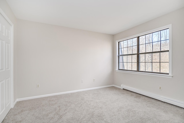 carpeted empty room with baseboard heating and baseboards