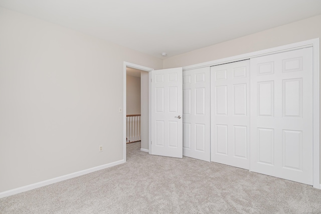 unfurnished bedroom featuring carpet floors, a closet, and baseboards