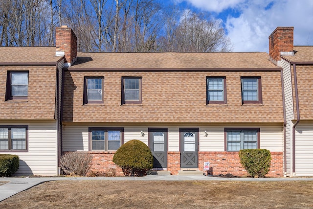 view of front of home featuring a shingled roof, entry steps, and a chimney